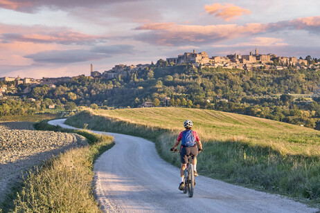 Una donna in bici elettrica nella regione del Chianti in Toscana foto iStock.