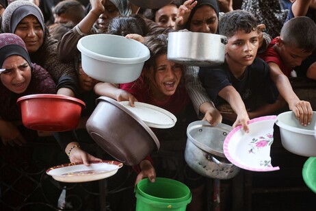 Gaza, famiglie palestinesi attendono pasti preparati da volontari