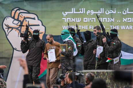 Palestinian Hamas fighters escort Israeli hostages Or Levy (2nd-L) and Eli Sharabi (2nd-R)