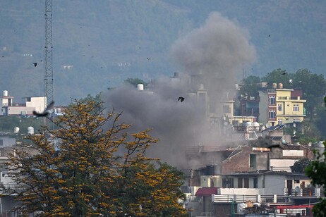Smoke billows after an artillery shell landed in the main town of Poonch district in India's Jammu