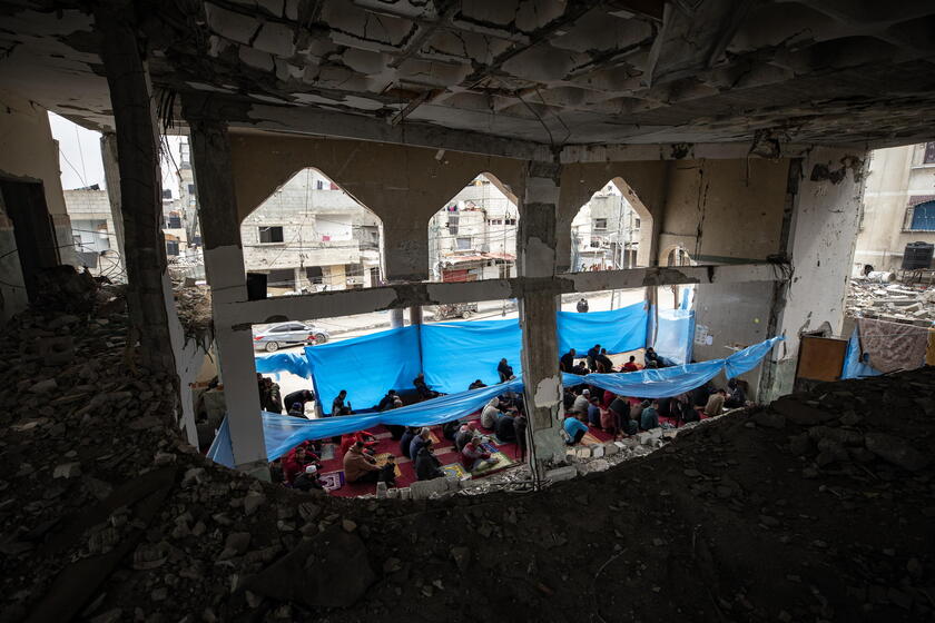 Palestinians perform Friday prayers in the ruins of Al-Huda Mosque © ANSA/EPA