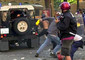 Una delle fotografie messe in rete sul sito di Radio Sherwood, in cui si vede Carlo Giuliani (in  basso a destra, parzialmente coperto da un altro manifestante) che raccoglie da terra un estintore. Dalla camionetta dei carabinieri spunta una pistola © Ansa