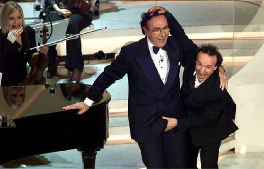 Roberto Benigni 'tocca' Pippo Baudo sul palco del teatro Ariston durante l'ultima serata del 52/o Festival della Canzone Italiana, vinto dai Matia Bazar nel 2002 con il brano 'Messaggio d' amore' © Ansa