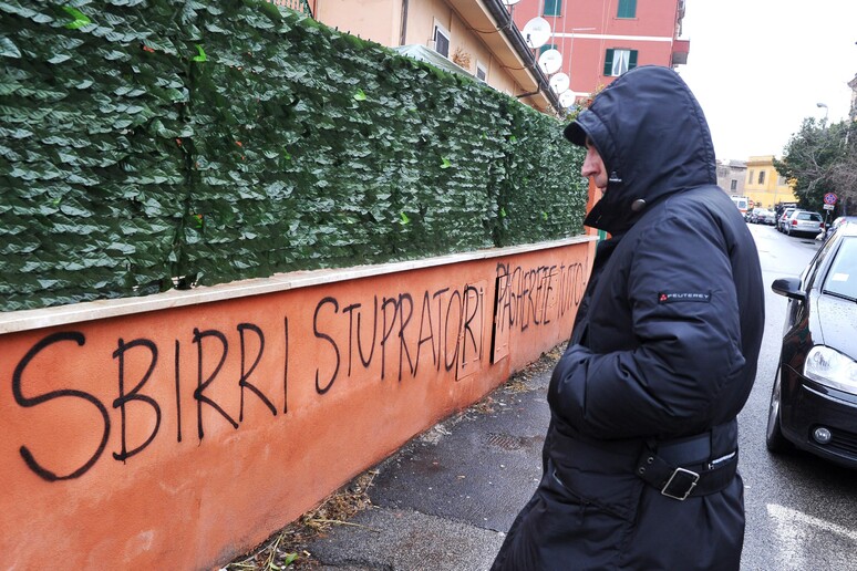 La scritta apparsa contro i carabinieri su un muretto nei pressi della caserma del Quadraro dopo quanto accduto - RIPRODUZIONE RISERVATA