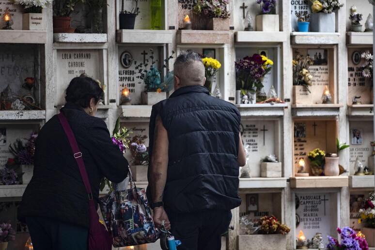 Visitatori portano fiori sulle tombe dei propri cari - RIPRODUZIONE RISERVATA