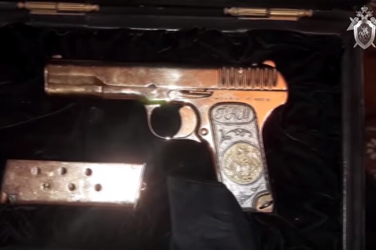Un fermo immagine della pistola d 'oro sequestrata al primo ministro ad interim del governo locale del Daghestan - RIPRODUZIONE RISERVATA