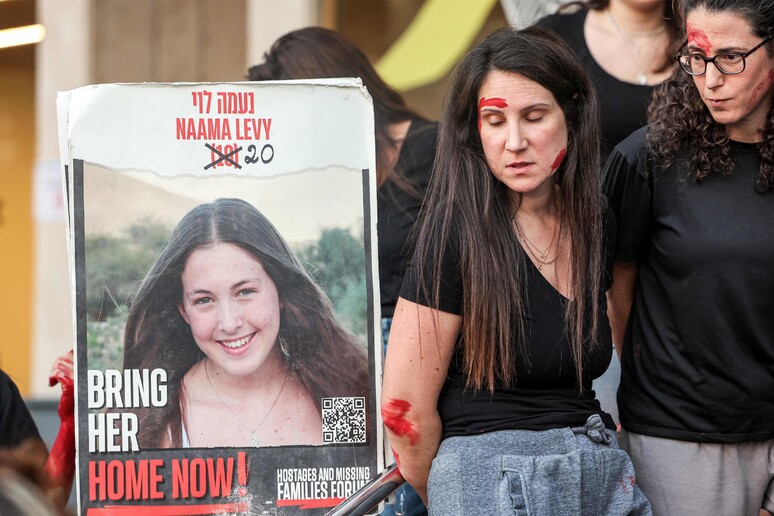 Women demonstrators dressed up as Israeli hostage Naama Levy © ANSA/AFP