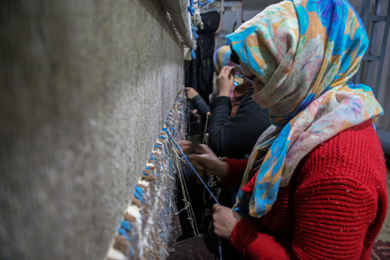Donne afghane mentre tessono © ANSA/EPA